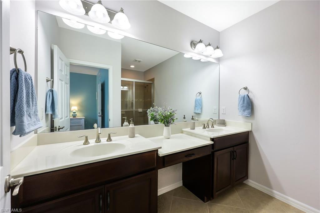 Bathroom featuring tile patterned flooring and double sink vanity