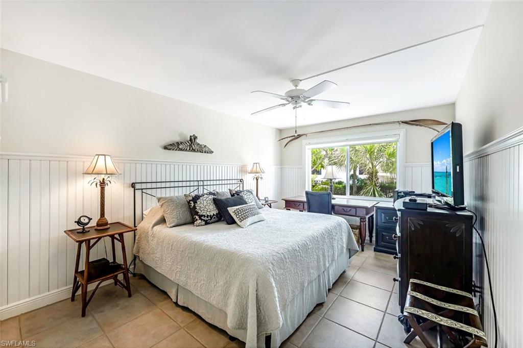 Tiled bedroom featuring ceiling fan