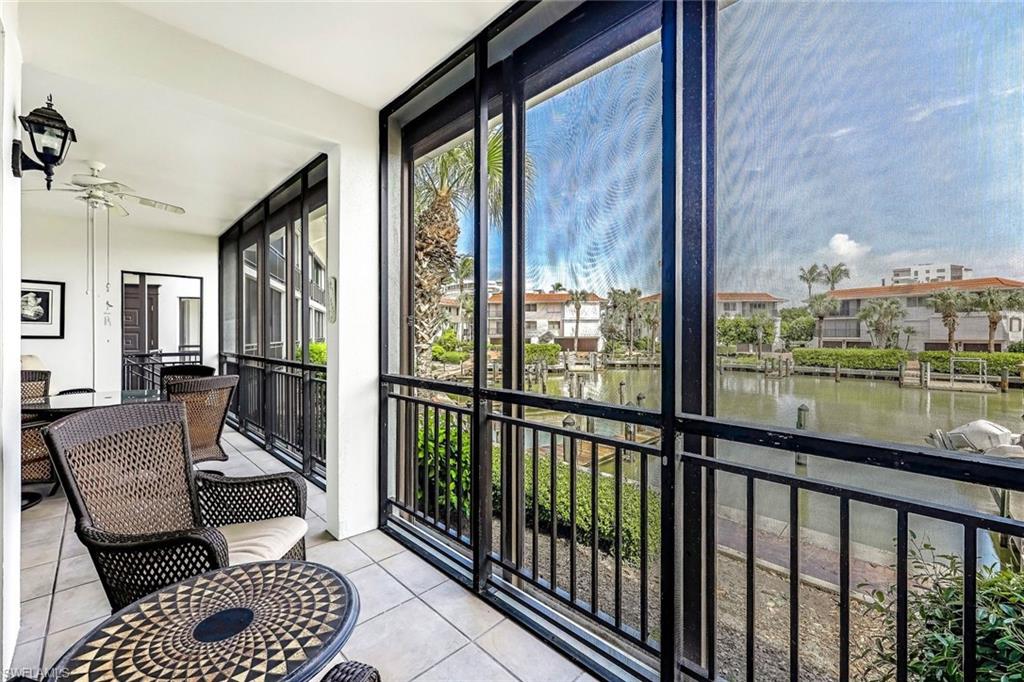 Sunroom / solarium featuring a water view and ceiling fan