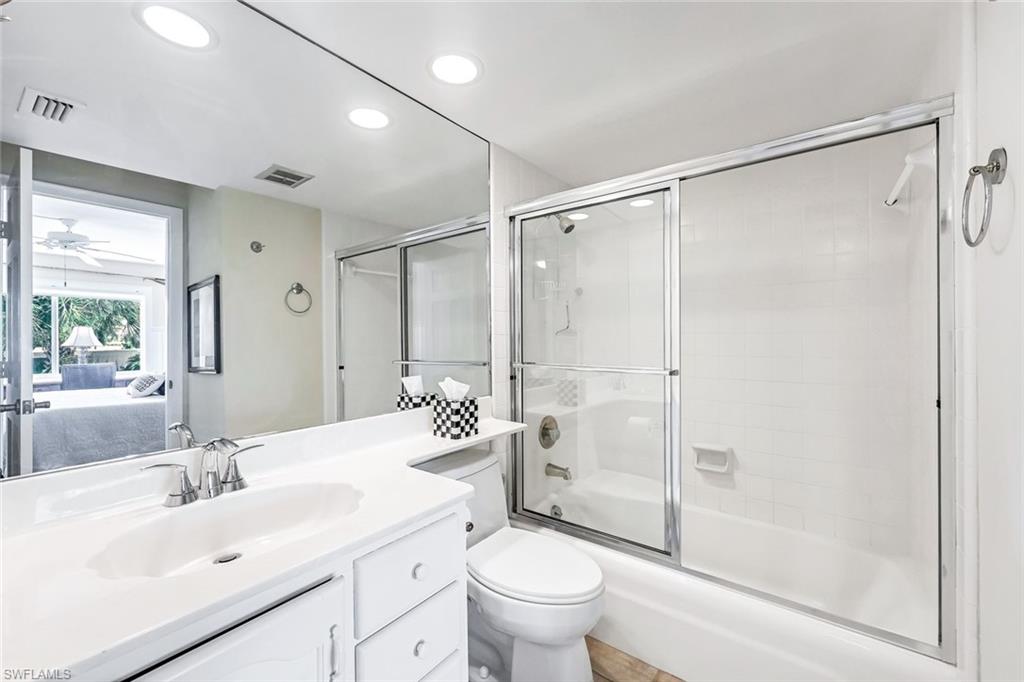 Full bathroom featuring ceiling fan, toilet, shower / bath combination with glass door, and vanity