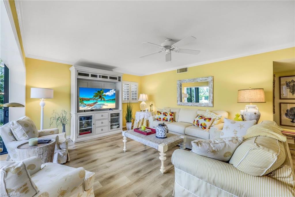 Living room featuring crown molding, ceiling fan, and light hardwood / wood-style floors