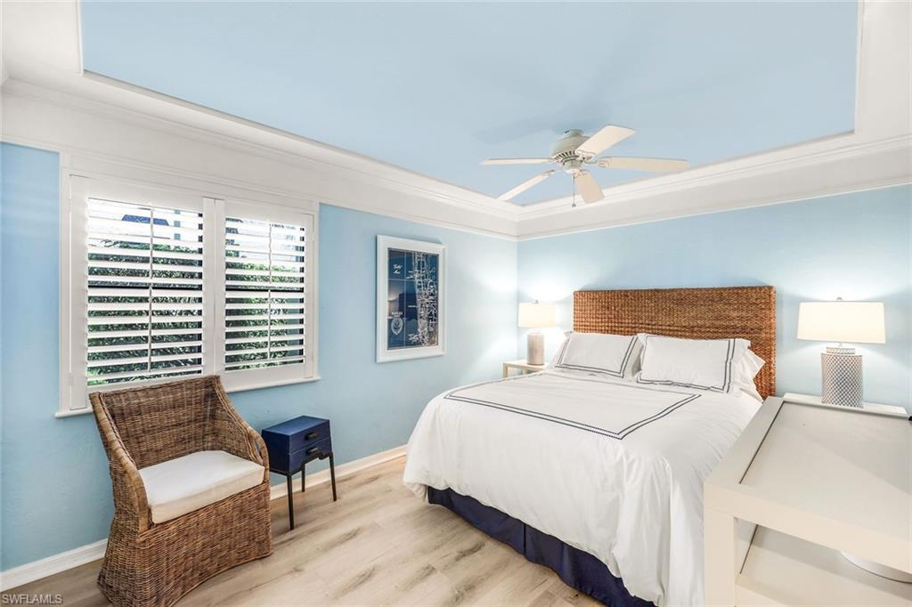 Bedroom with ceiling fan, crown molding, and light hardwood / wood-style flooring