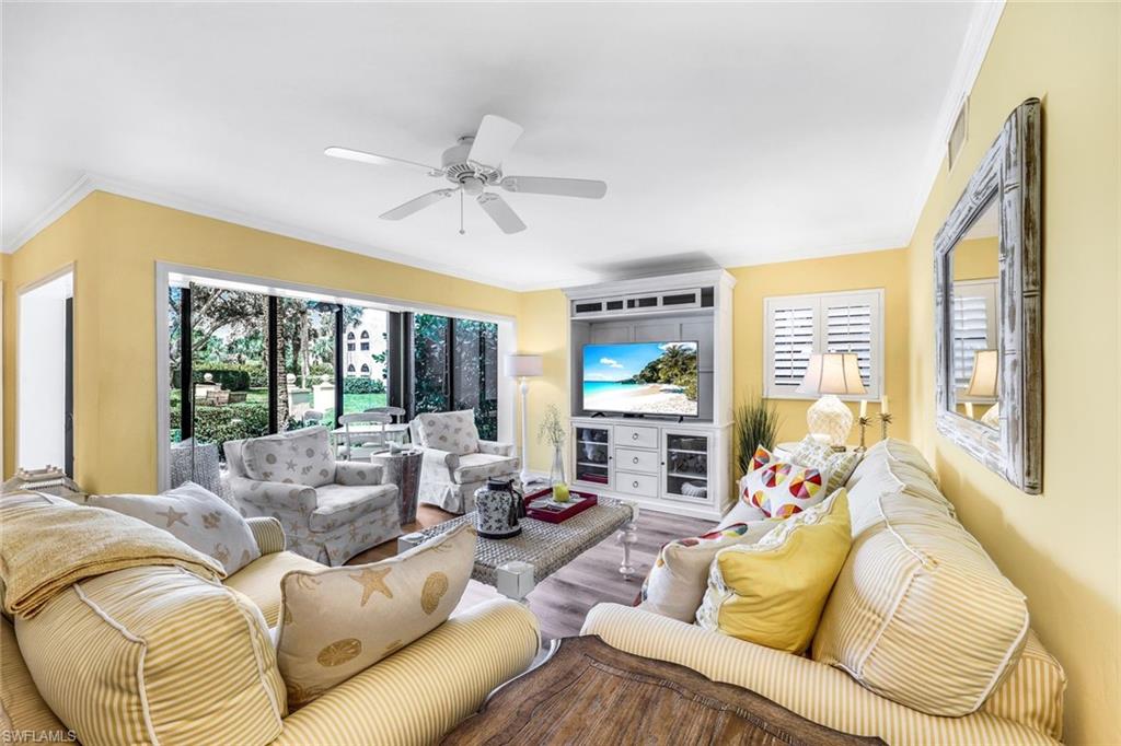 Living room featuring crown molding, ceiling fan, and hardwood / wood-style flooring