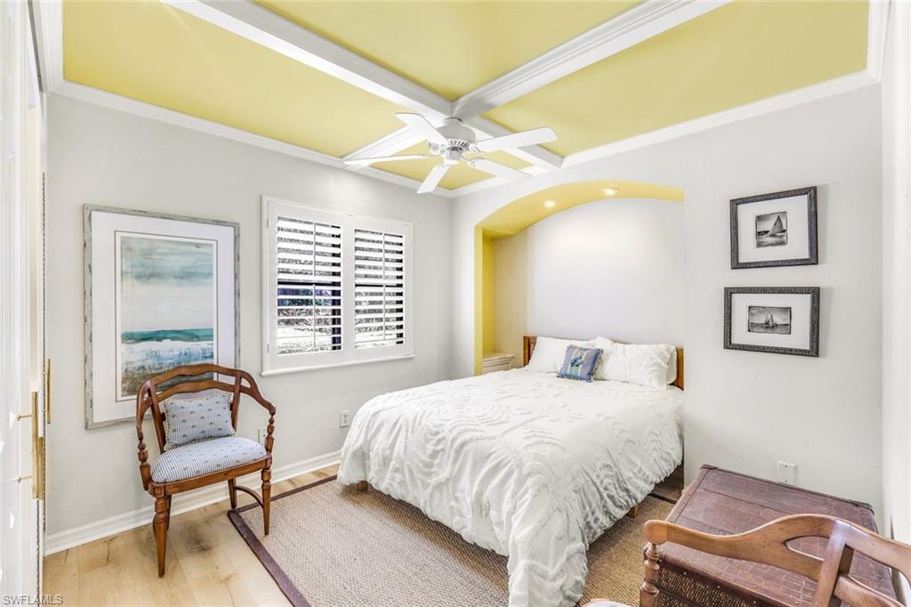 Bedroom featuring light hardwood / wood-style flooring, ornamental molding, and ceiling fan