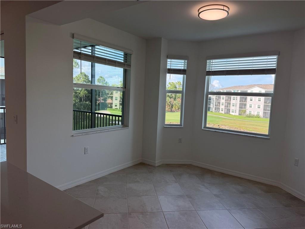 Dining area featuring a bay window configuration, tile flooring, and a flush-mount ceiling light
