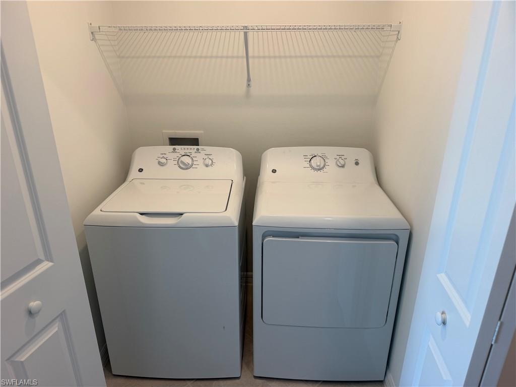 Dedicated laundry closet featuring a top-load washer, a front-load dryer, and an upper wire storage shelf