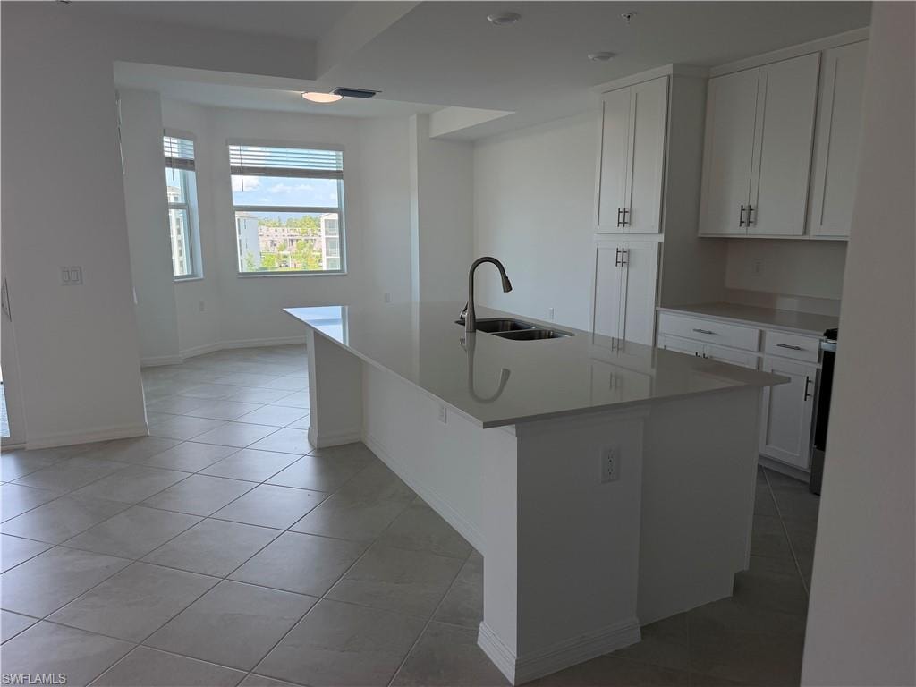 Modern kitchen featuring a large island with an undermount sink and a gooseneck faucet