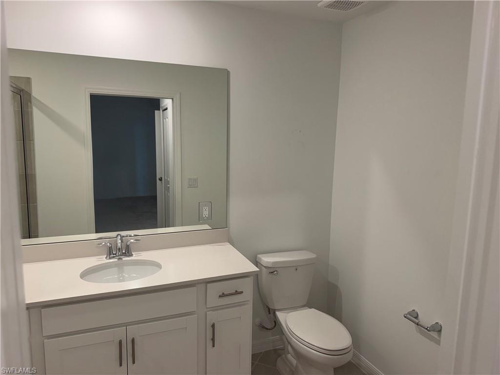 Bathroom featuring a white vanity with an integrated sink, polished chrome faucet, and a large wall-mounted mirror
