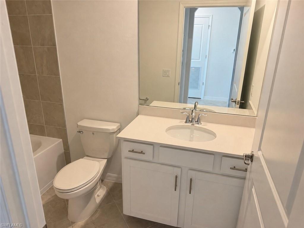 Bathroom featuring a white vanity with an integrated sink, polished chrome faucet, and rectangular mirror
