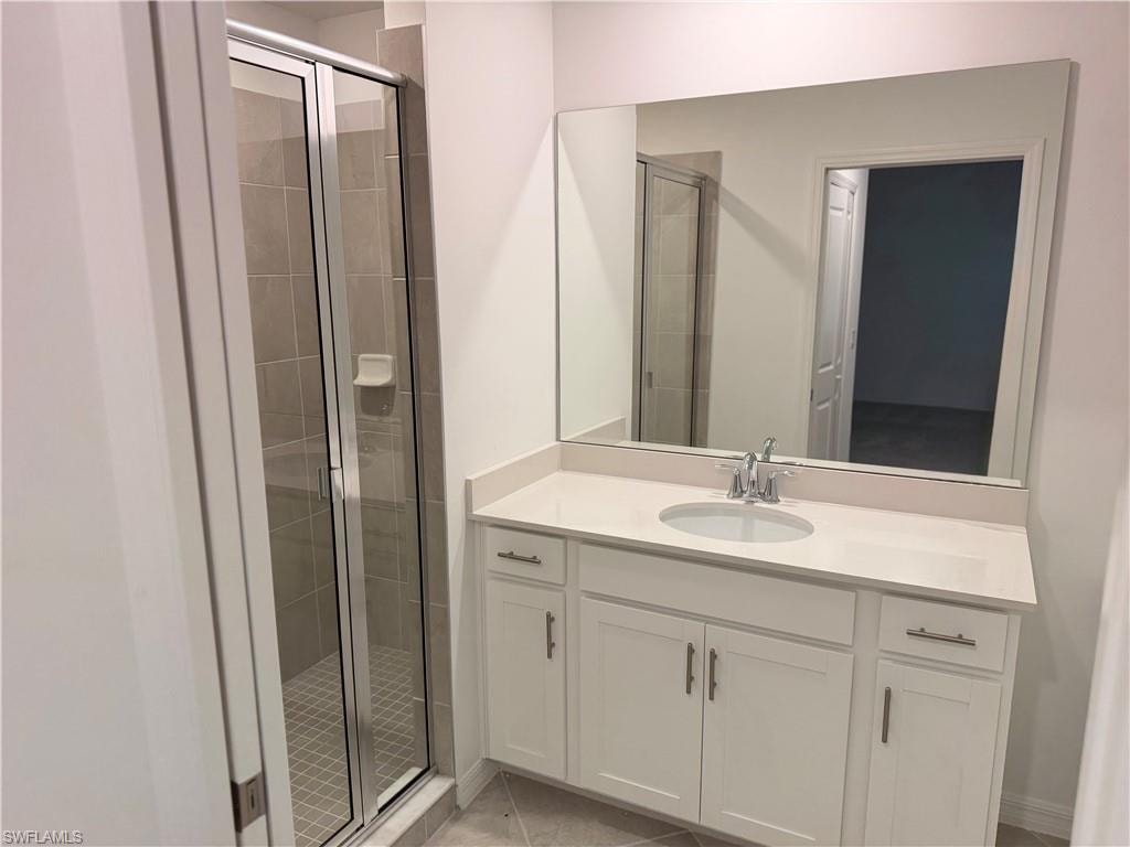 Bathroom vanity featuring a light-toned countertop, undermount sink, and chrome fixtures