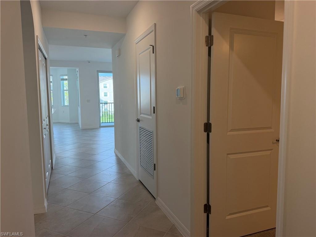 Hallway featuring diagonal tile flooring, white interior doors, and recessed lighting