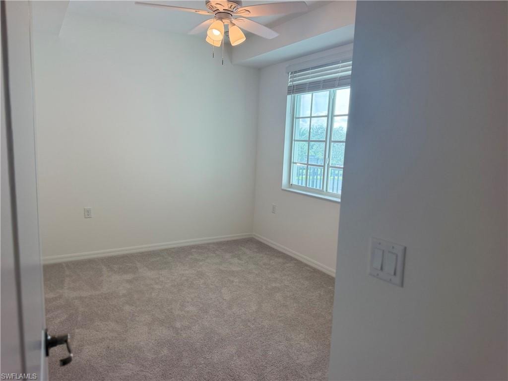 Carpeted interior room featuring a ceiling fan with integrated lighting, a single window with horizontal blinds, and white walls