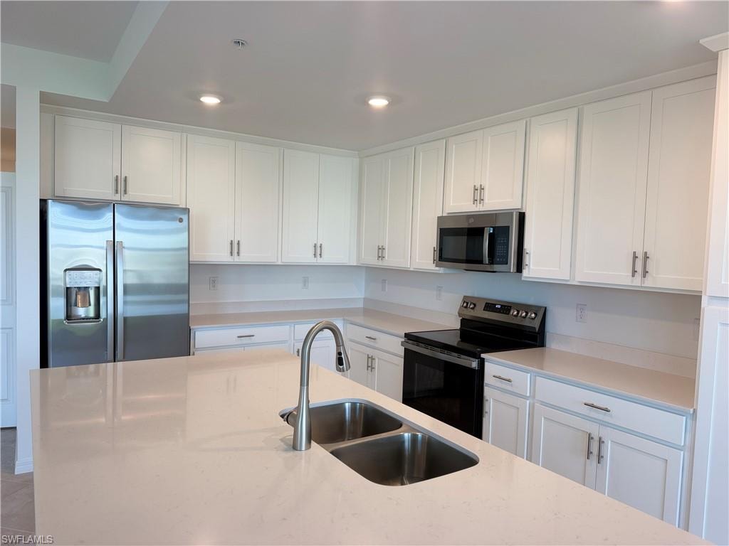 Contemporary kitchen featuring an expansive island with an undermount double-basin sink and brushed nickel faucet