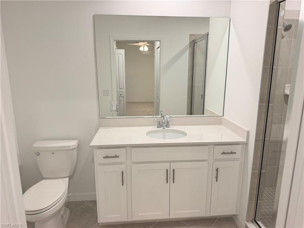 Bathroom featuring a white vanity with a quartz-finish countertop, undermount sink, and chrome faucet