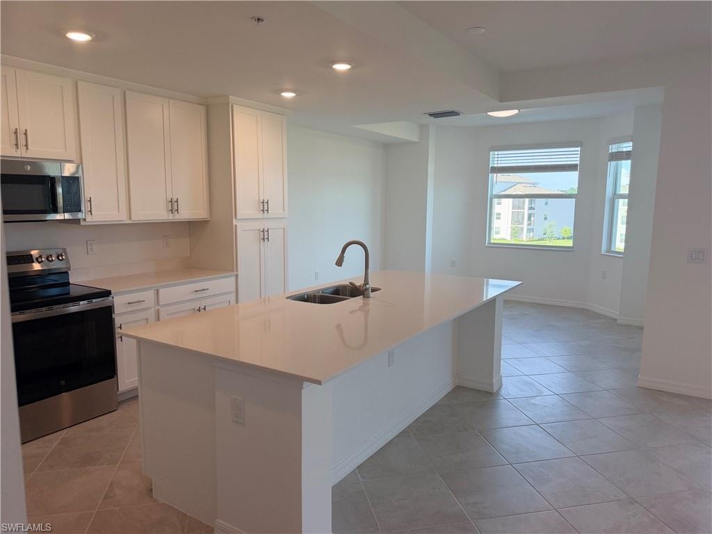 Modern kitchen featuring a large island with an undermount sink and gooseneck faucet