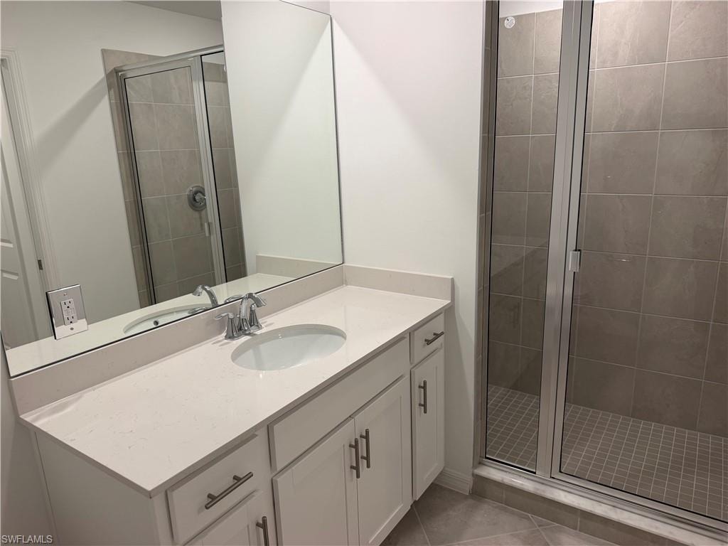 Bathroom vanity featuring a white countertop with an integrated sink, chrome faucet, and white cabinetry with brushed nickel hardware