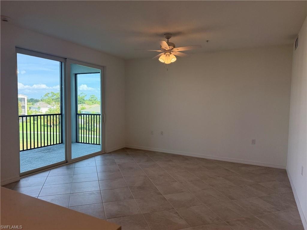 Spacious room featuring large format tile flooring and a ceiling fan with integrated lighting