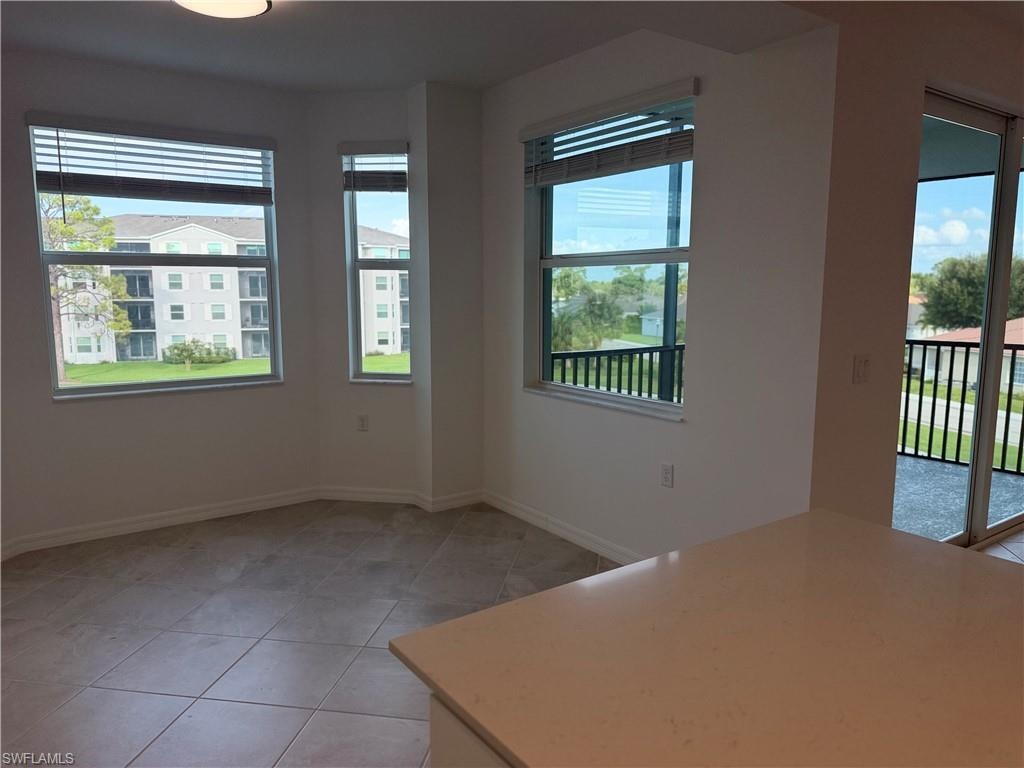 Spacious room featuring multiple windows with horizontal blinds, providing natural light