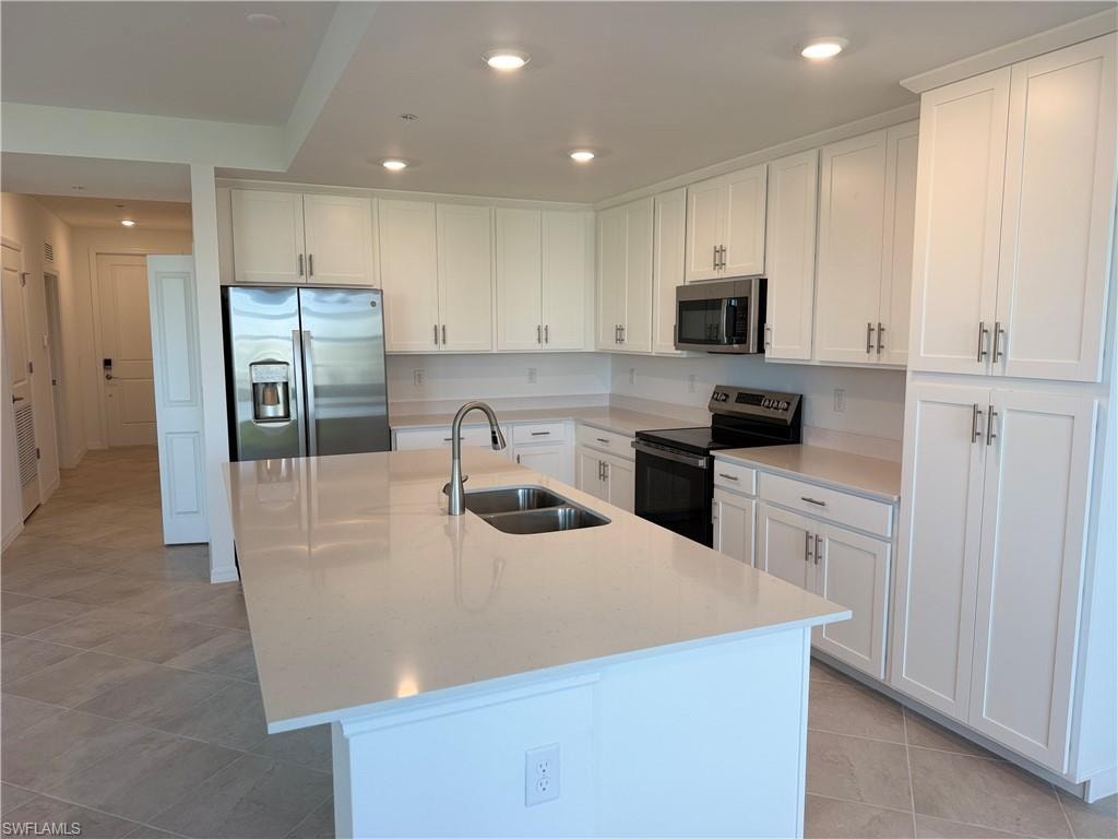 Kitchen featuring an expansive island with a double basin sink and gooseneck faucet