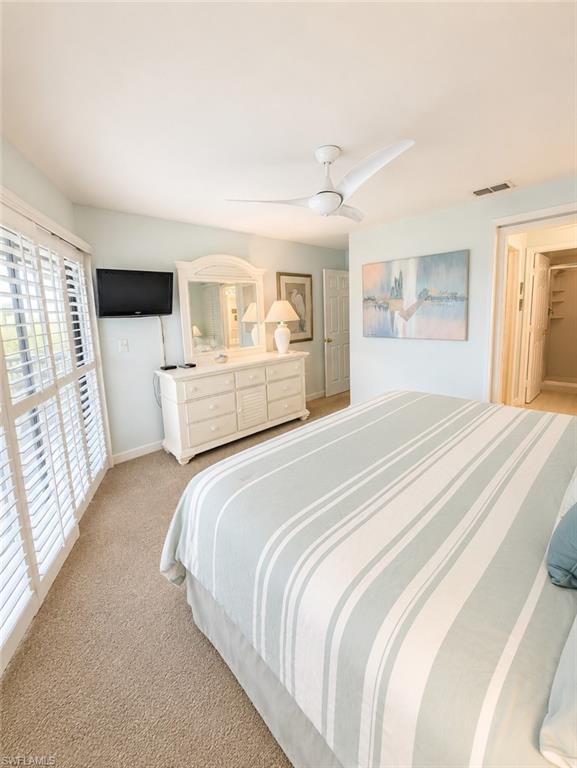 Carpeted room featuring a ceiling fan, light blue wall paint, and white plantation shutters
