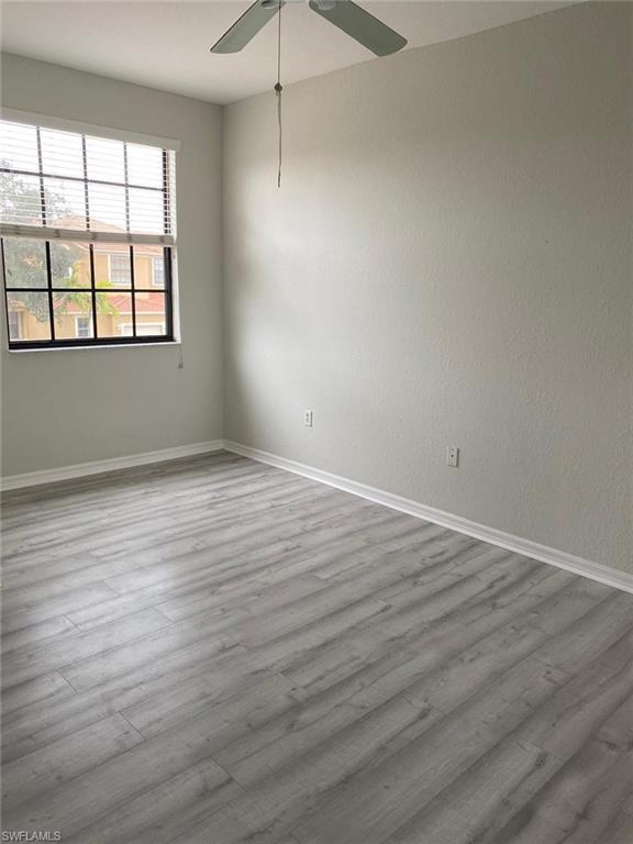 Light grey wood-finish flooring with white baseboards