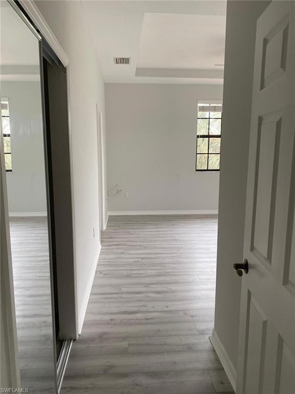 Spacious interior featuring light wood-finish flooring, white baseboards, and neutral wall tones
