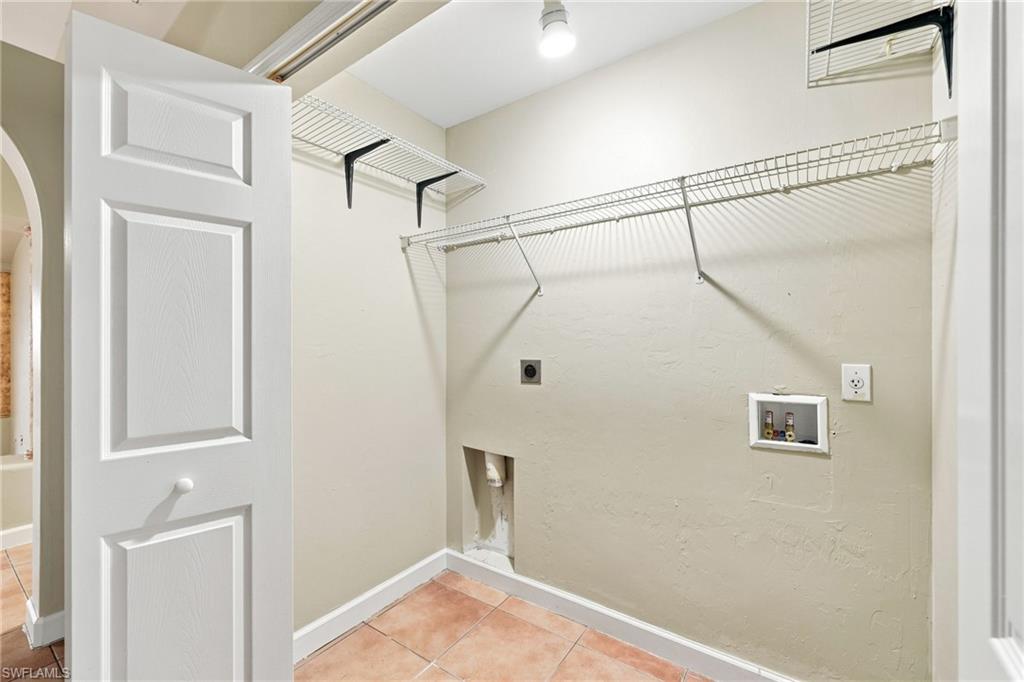 Spacious walk-in closet featuring wire shelving, generous hanging rod, terracotta tile flooring, and abundant storage capacity with direct access from the primary living area