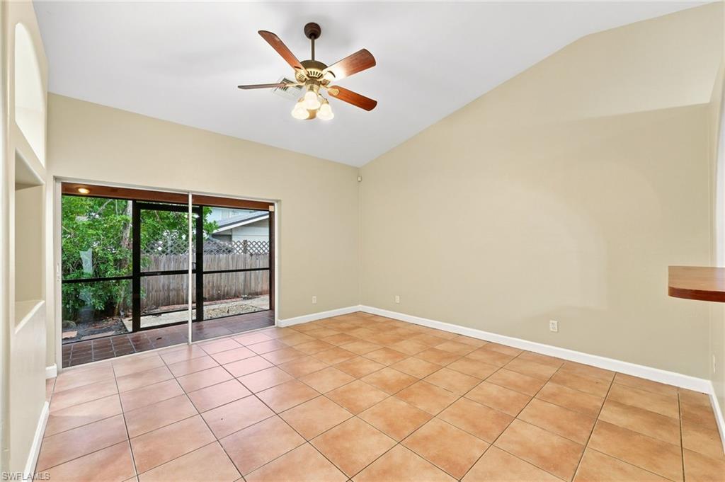 Spacious room featuring vaulted ceilings, a ceiling fan with light kit, and neutral wall tones