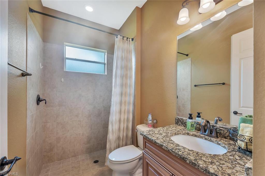 Bathroom featuring a shower with tiled walls and a privacy window