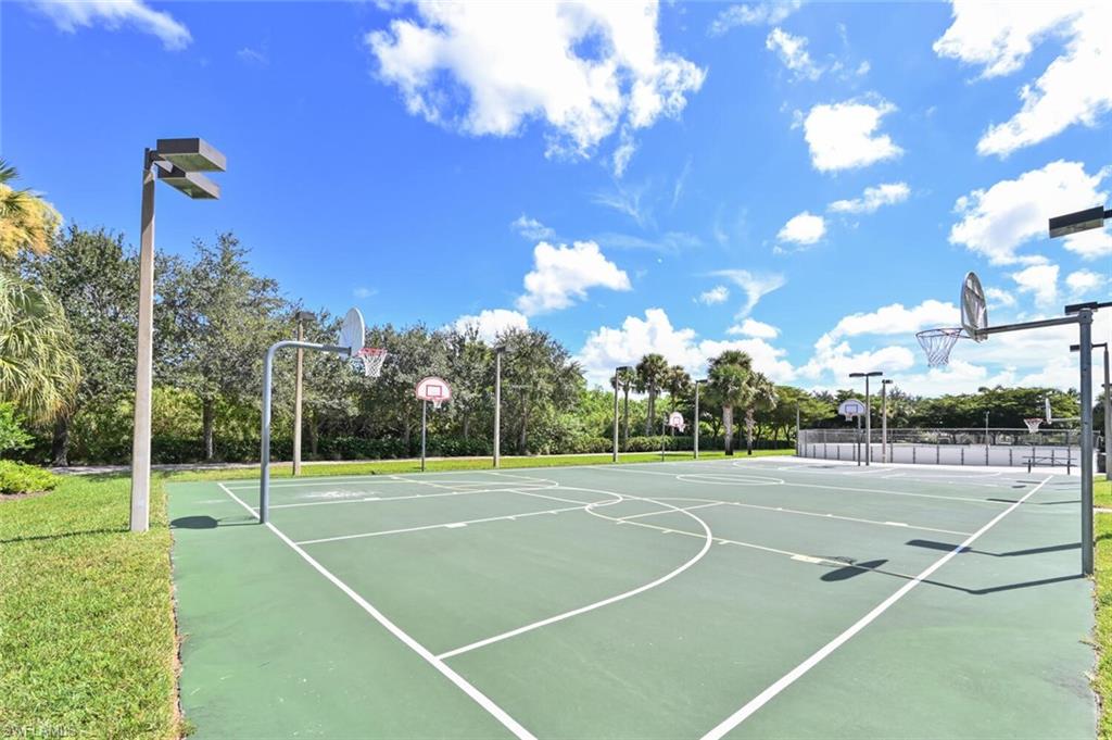 Multi-court outdoor athletic area featuring two basketball courts, an additional court with a white perimeter fence, and multiple overhead lighting fixtures