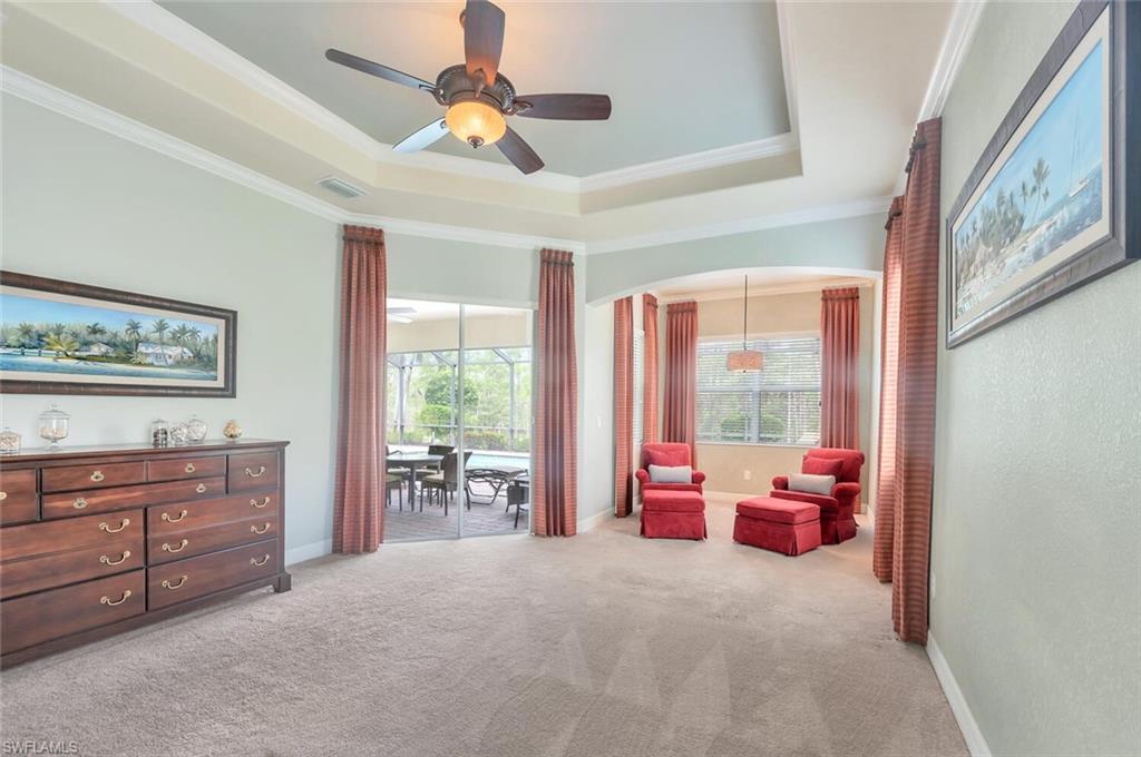 Recessed ceiling with crown molding, ceiling fan, and carpeted flooring