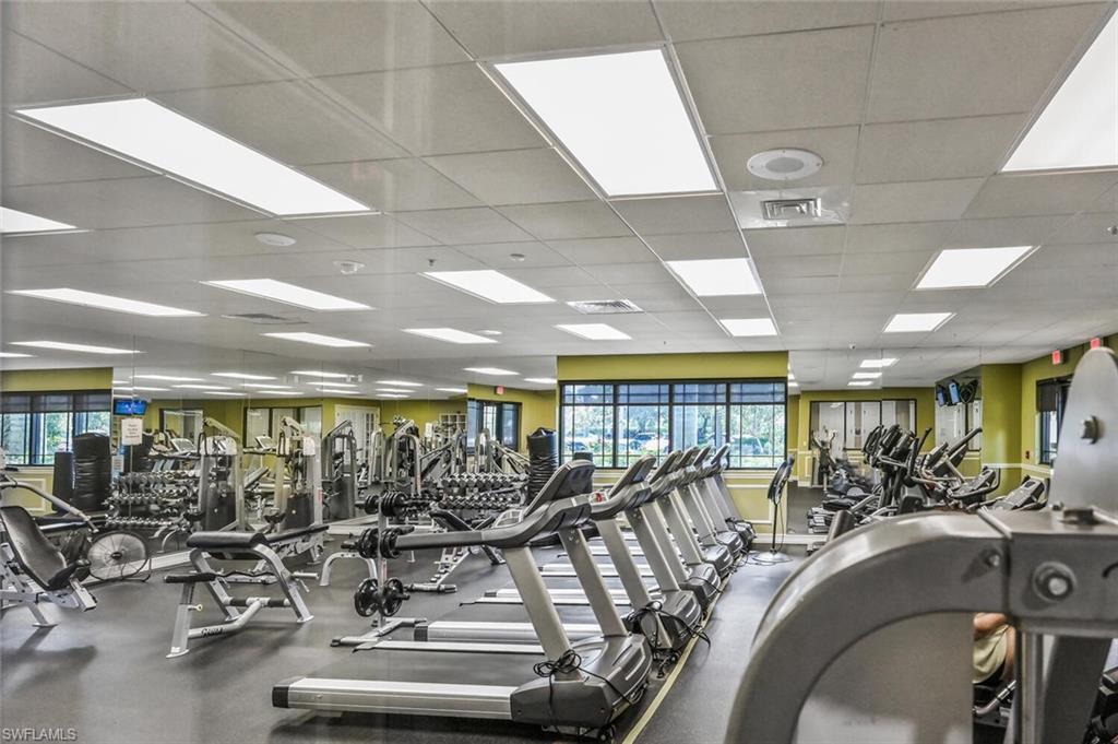 Fitness center featuring multiple treadmills, elliptical machines, and strength training equipment