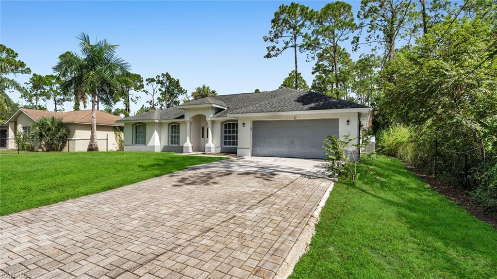 Front elevation with paver driveway and two car attached garage