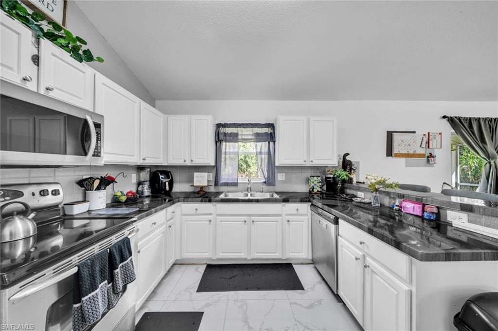 White cabinetry, granite counters and stainless appliances