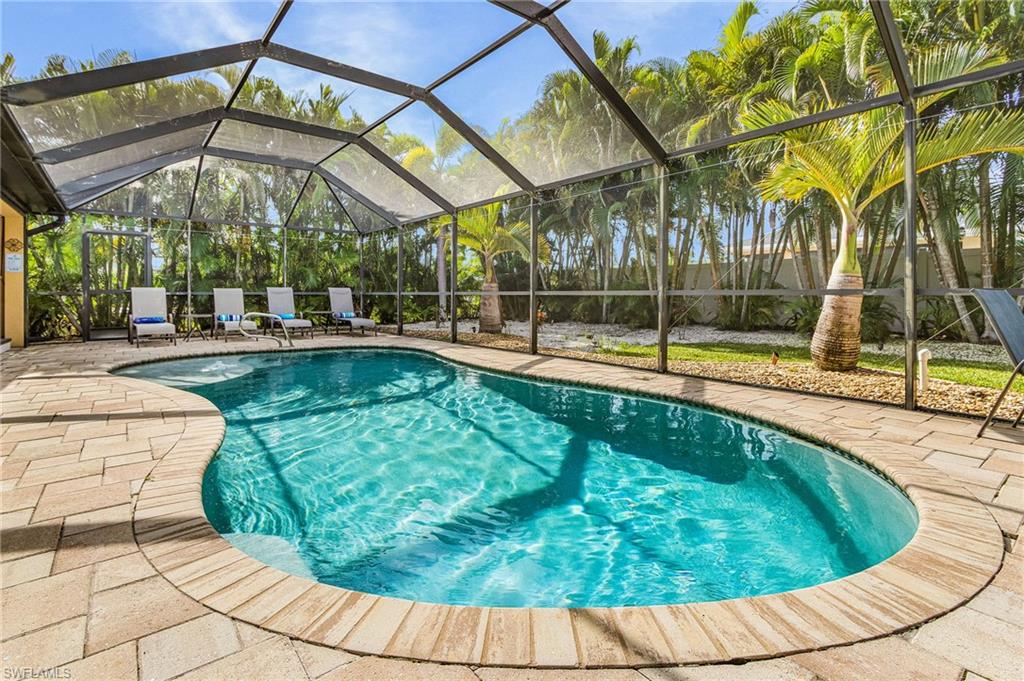 Custom-shaped swimming pool with a screen enclosure