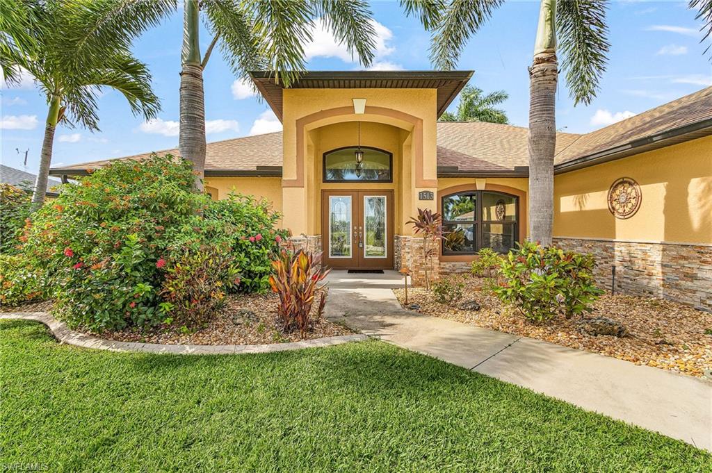 Stucco exterior with stone veneer accents and a prominent entryway