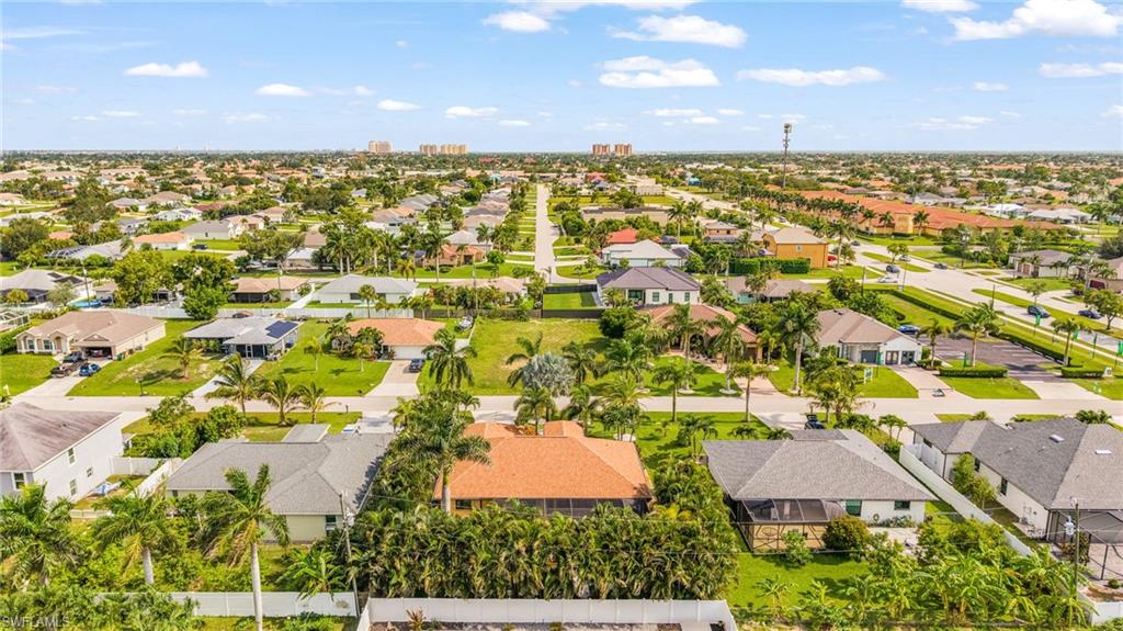 Residential neighborhood featuring a mix of single-story homes, mature landscaping, and an undeveloped lot
