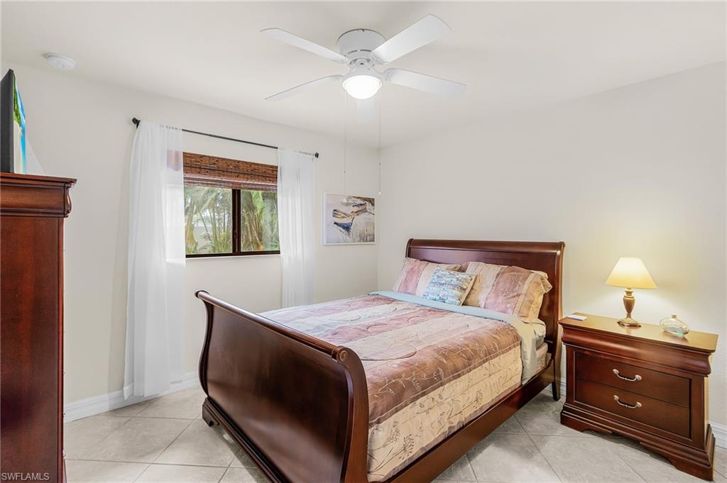 Interior space featuring tile flooring, white walls, and a ceiling fan with integrated lighting