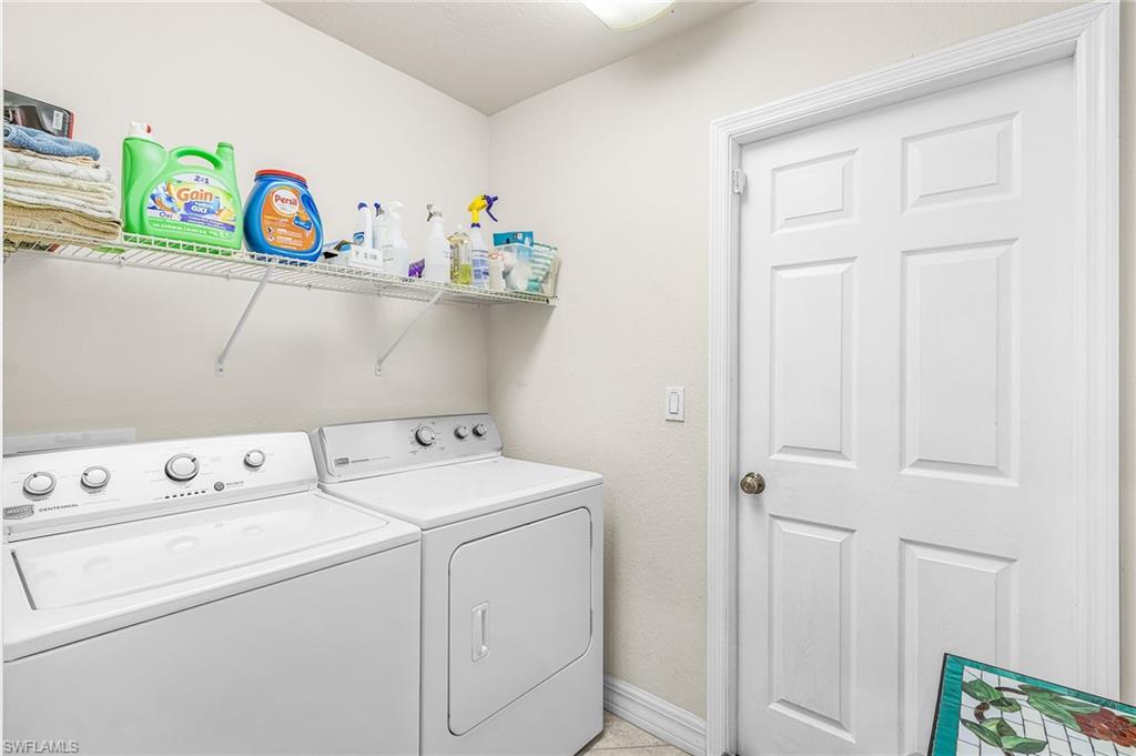 Dedicated laundry area featuring a white top-load washing machine and front-load dryer