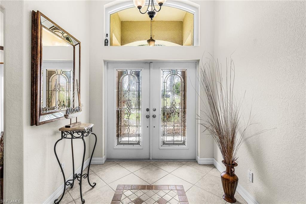 Double entry doors with decorative glass panels and transom window