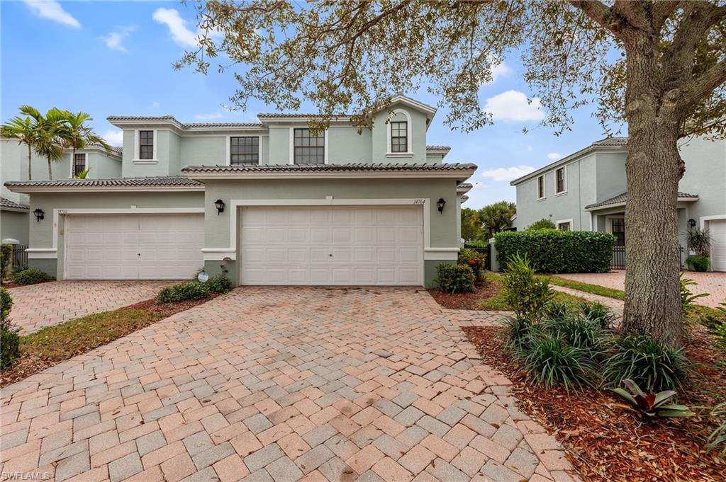 Mediterranean / spanish home featuring a garage, decorative driveway, stucco siding, and a tile roof