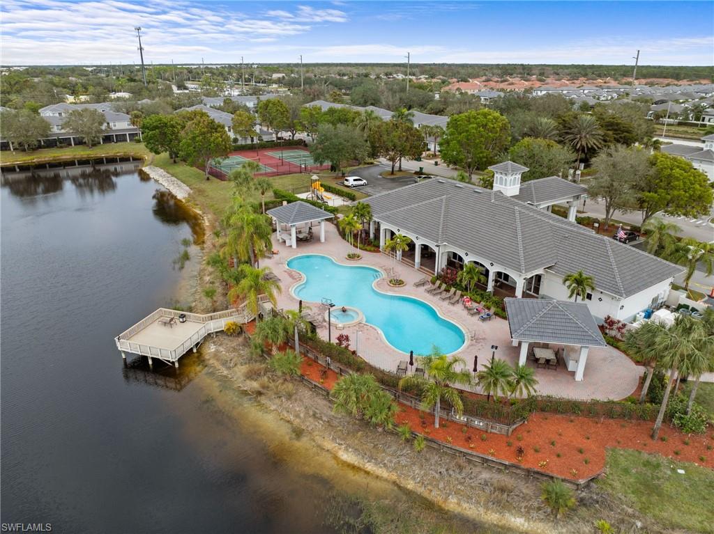 Drone / aerial view of a nearby body of water and a pool area
