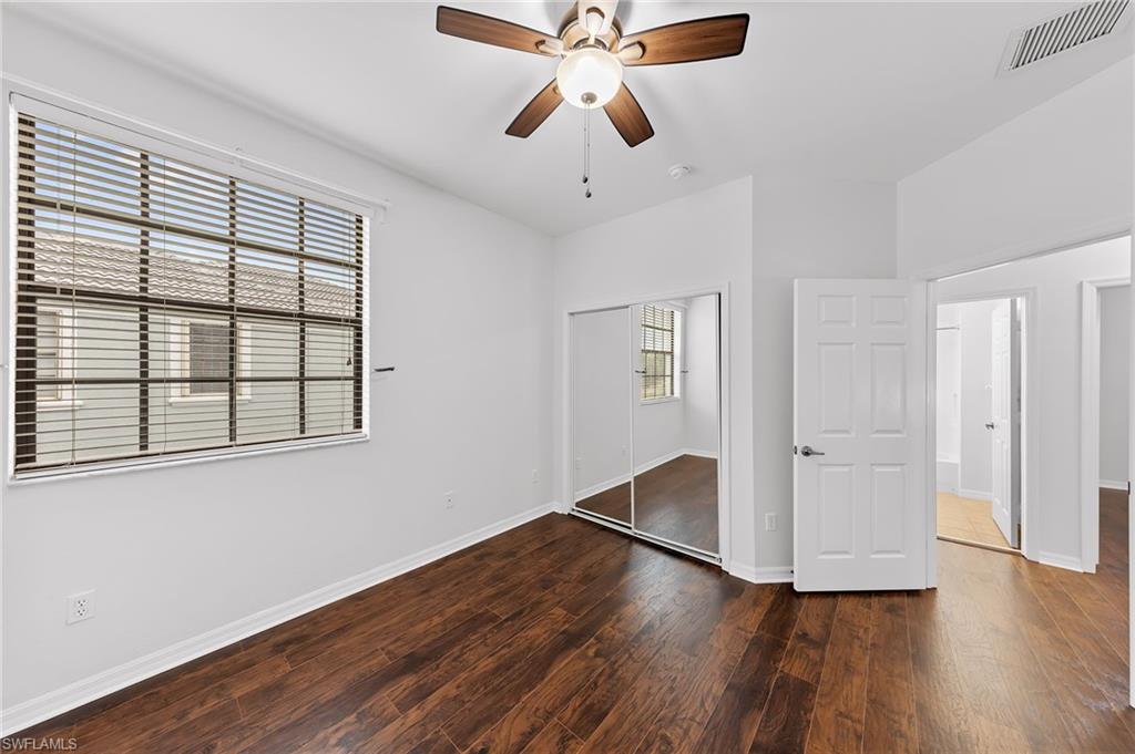 Unfurnished bedroom with dark wood-style flooring, a closet, and ceiling fan