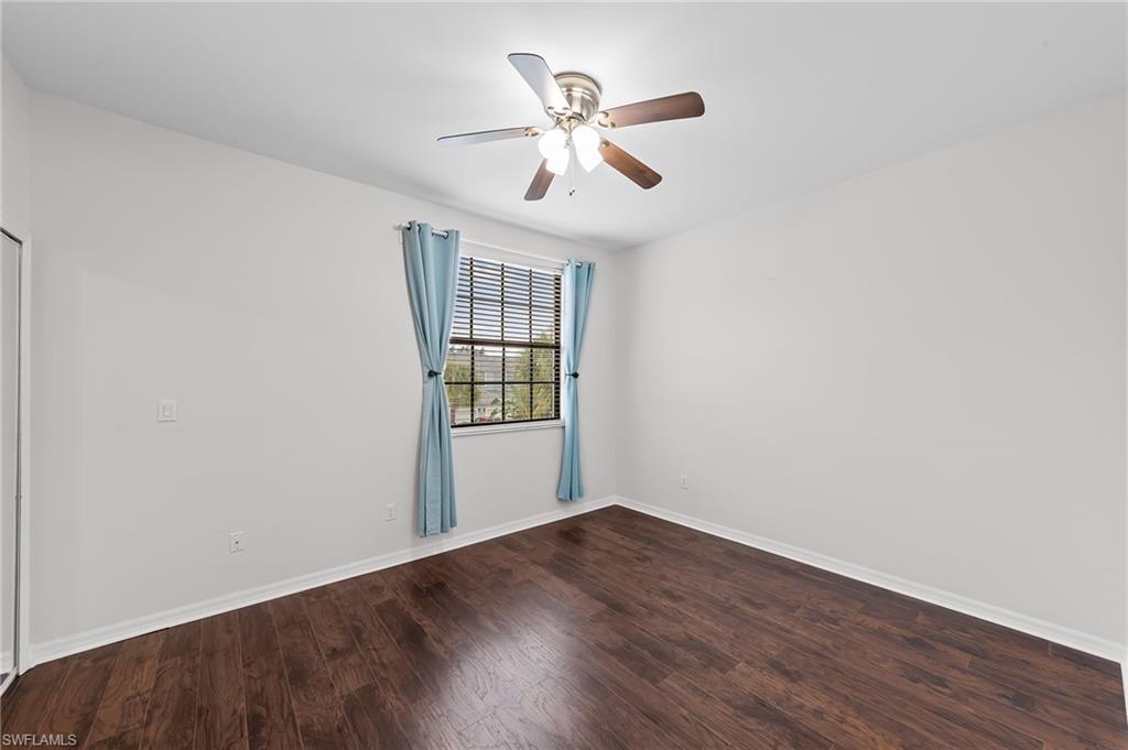 Spare room featuring dark wood-style flooring and a ceiling fan