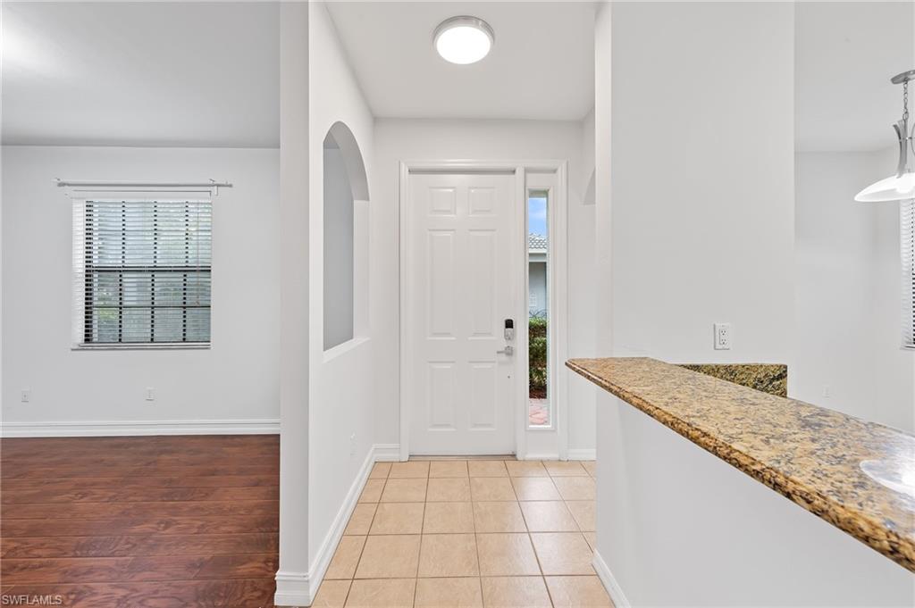 Entrance foyer with baseboards and light wood-style floors