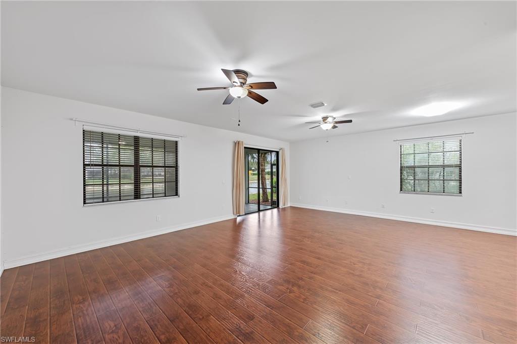 Unfurnished room featuring dark wood-type flooring and ceiling fan