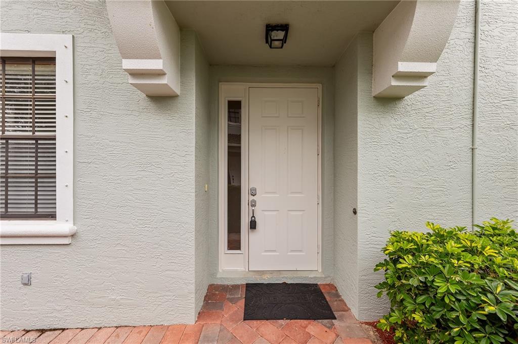 Doorway to property featuring stucco siding