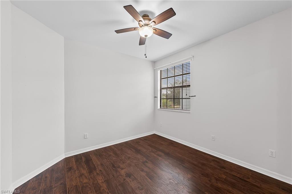 Spare room with dark wood-type flooring and a ceiling fan