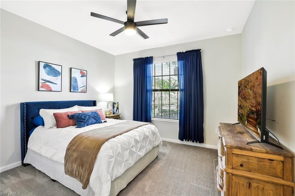 Carpeted bedroom featuring a contemporary ceiling fan, window with blinds and drapes, and recessed lighting