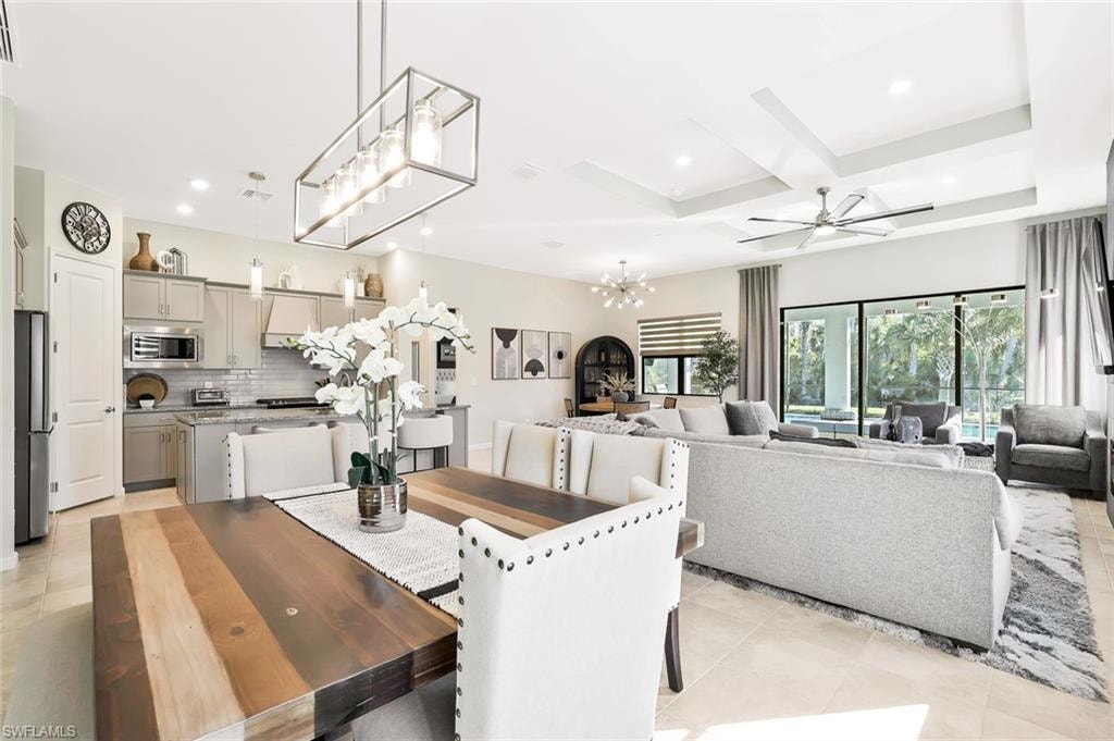 Open-concept living space featuring a tray ceiling, recessed lighting, and tile flooring